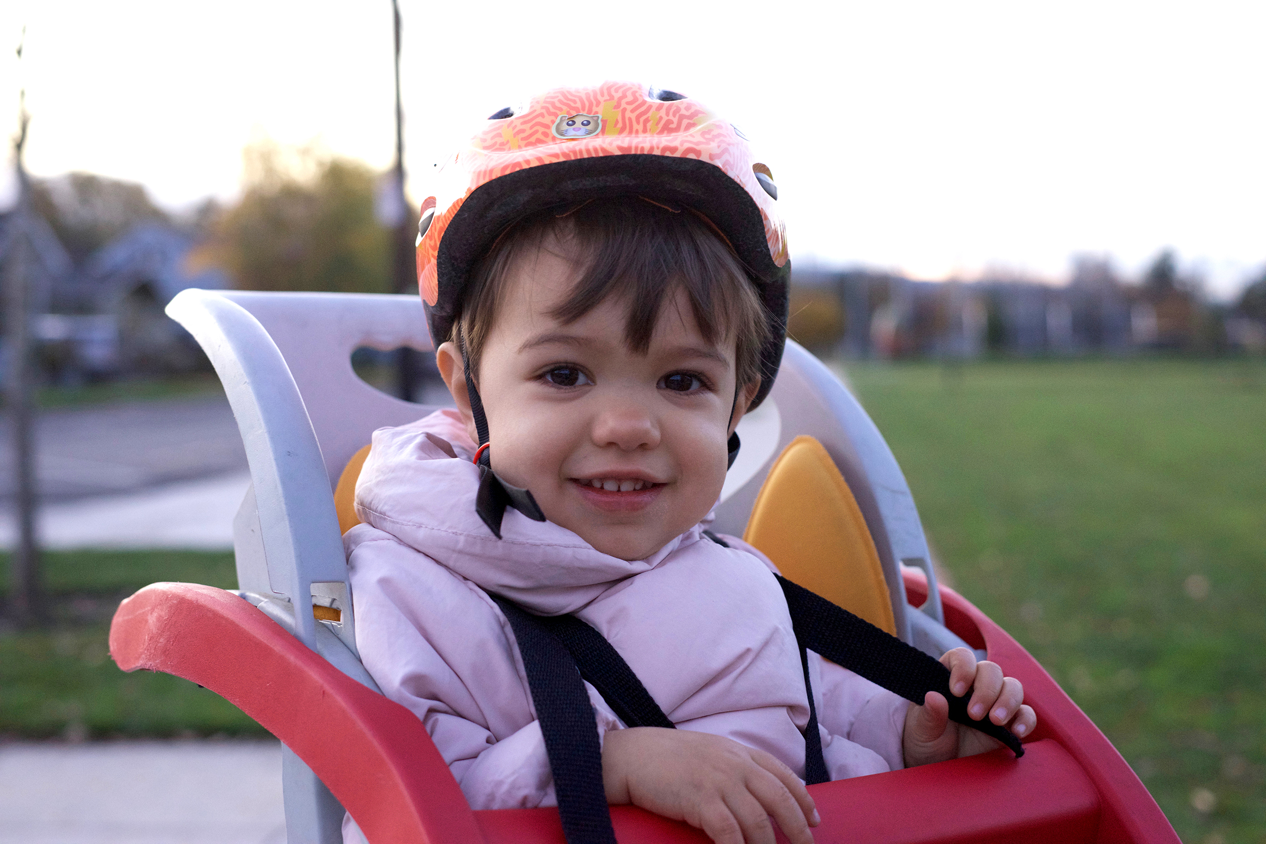 Child wearing a bike helmet and sitting on a bike